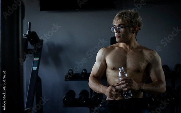 Obraz Athletic shirtless handsome young man, muscular young men are exercising with weights in a gym.
