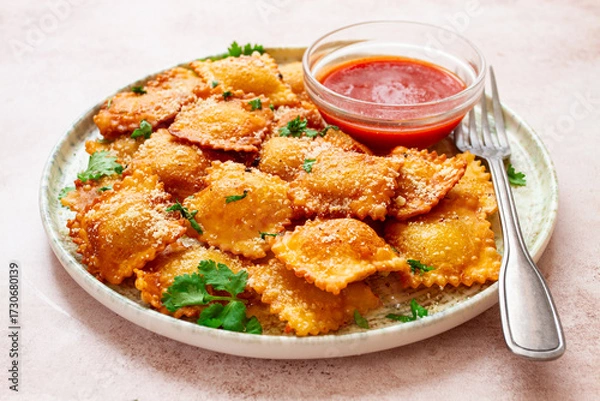 Obraz fried ravioli with parmesan cheese, served with red sauce and garnished with herbs, on a light background, no people,