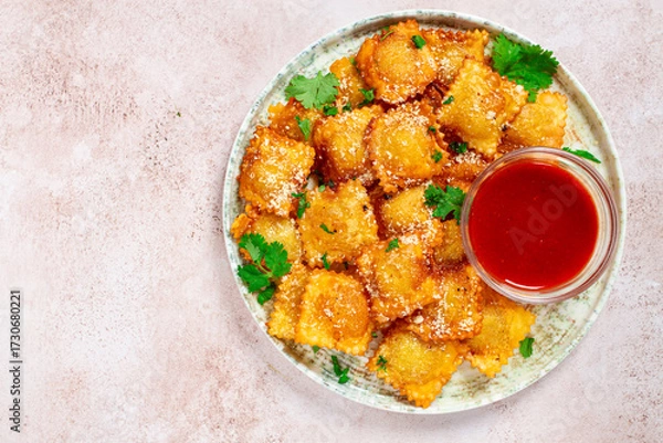 Obraz fried ravioli with parmesan cheese, served with red sauce and garnished with herbs, on a light background, no people,