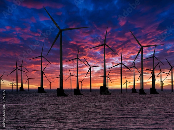 Fototapeta Windfarm or wind turbines off shore on sunset