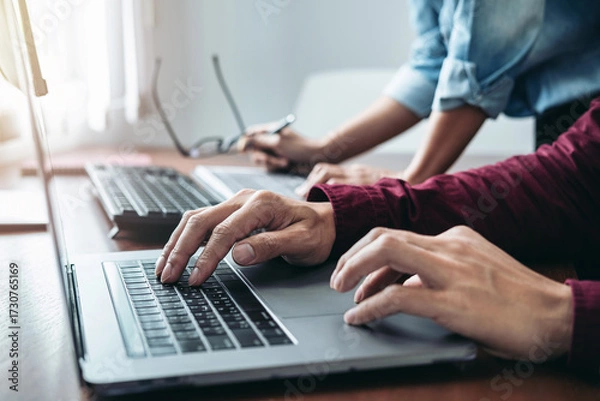 Obraz Asian man programmer looking code data on laptop to brainstorming with partner about new project