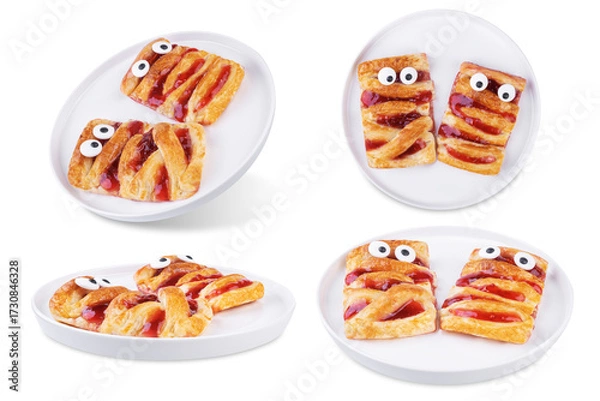 Fototapeta Puffed cakes with raspberry jam in the form of mummy for Halloween holidays on a white isolated background