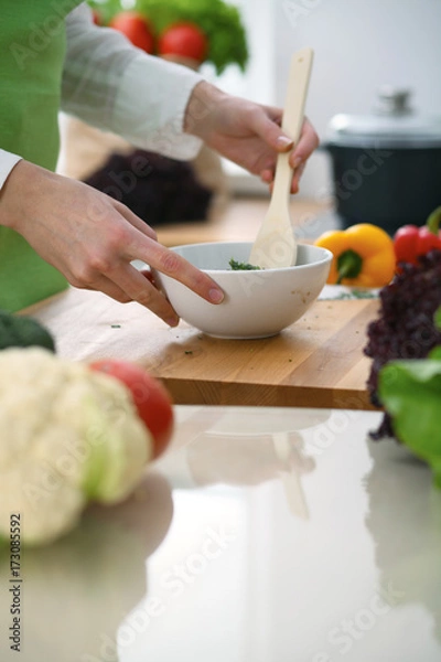 Obraz Closeup of human hands cooking vegetables salad in kitchen on the glass  table with reflection