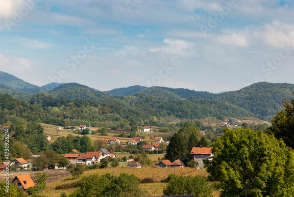 Fototapeta Rural landscape in the mountainous part of the Balkans with scattered houses on the mountain slopes