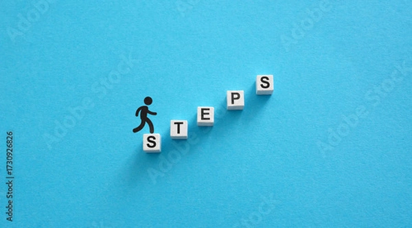 Fototapeta Figure climbing the word steps symbolizing personal progress.