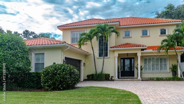 Obraz Naples property with palm fronds and a quiet front yard. Mediterranean facade with vibrant foliage and elegant architecture.