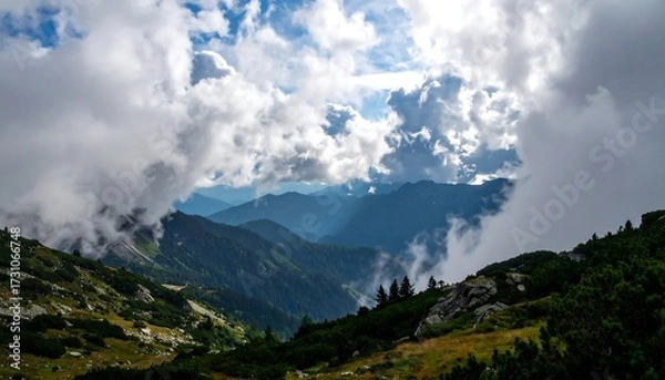 Fototapeta Mountain valley shrouded in clouds, sunlight breaks through