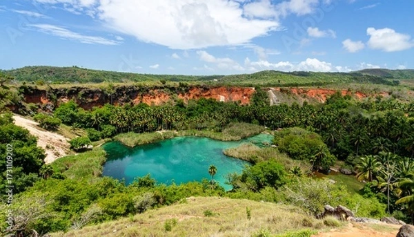 Fototapeta Vibrant Turquoise Lagoon Nestled in a Lush Jungle Below Red Clay Cliffs