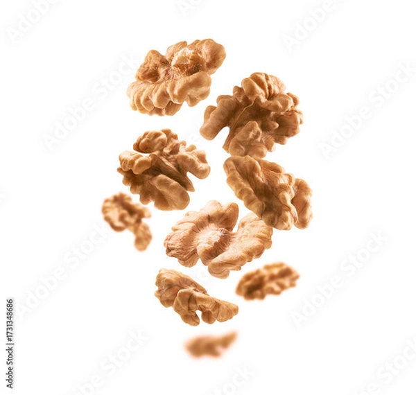Fototapeta Peeled from the shell, walnut kernels levitate on a white background