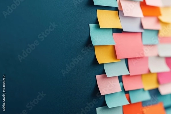 Fototapeta Colorful sticky notes arranged on a blue wall, creating a visual display of ideas, organization, and reminders