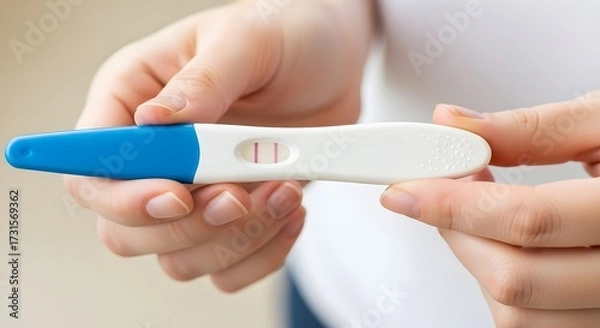 Fototapeta Positive Pregnancy Test A Close-Up View of a Woman's Hands Holding a Rapid Diagnostic Test Showing a Positive Result, Indicating Pregnancy