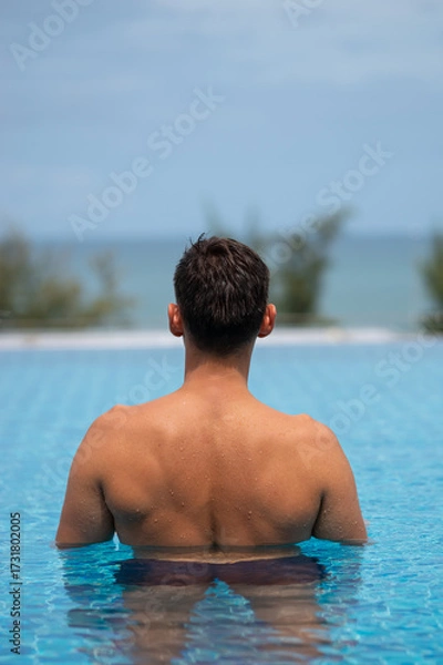 Obraz Tourist relaxing in infinity pool overlooking tropical ocean