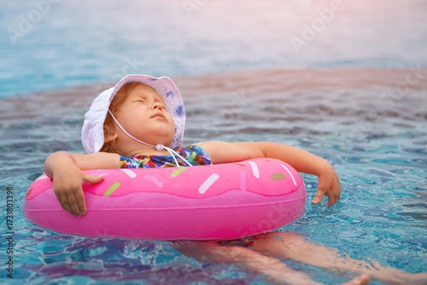 Obraz Little girl relaxing on inflatable ring in swimming pool