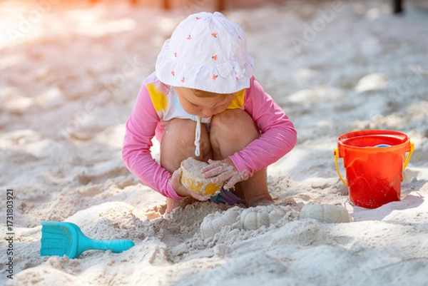 Obraz Little girl playing with sand mold on beach on sunny day