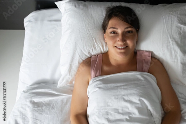 Obraz Woman smiling and relaxing in bed after waking up