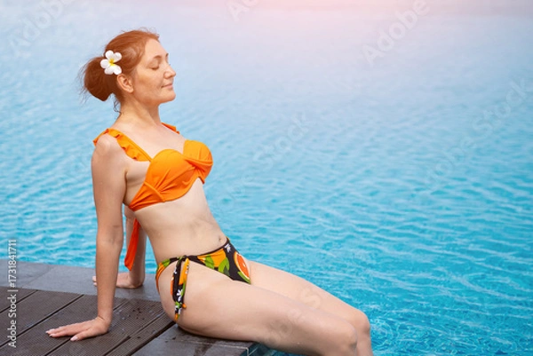 Obraz Tourist relaxing by the poolside enjoying summer vacation
