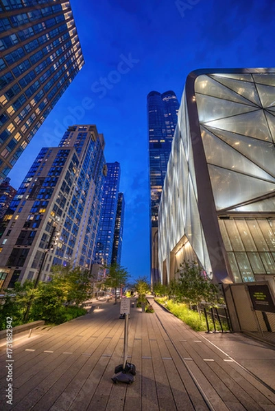 Fototapeta Wide view of the elevated urban park with skyscrapers and nighttime ambiance in Manhattan