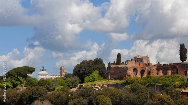 Fototapeta View of Rome historical center with Capitoline bell tower, Altar of Nation and Palatine Hill ancient ruins with beautiful clouds above