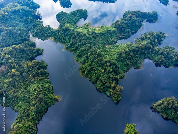 Fototapeta Mohamaya Lake is the second-largest artificial lake in Bangladesh, located in Mirsarai, Chittagong, Bangladesh. Aerial view of a tranquil lake with a pier and docked boats surrounded by lush greenery.