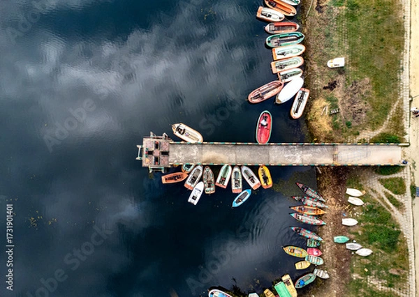 Fototapeta Mohamaya Lake is the second-largest artificial lake in Bangladesh, located in Mirsarai, Chittagong, Bangladesh. Aerial view of a tranquil lake with a pier and docked boats surrounded by lush greenery.