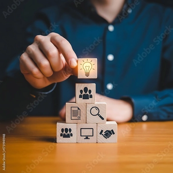 Fototapeta Person holding a wooden block with a light bulb icon, representing an idea