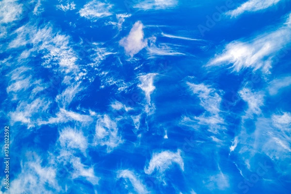 Fototapeta feathery sparse clouds in blue sky