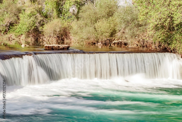 Fototapeta wide waterfall on the river, blurred movement of water