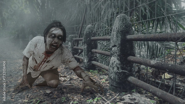 Fototapeta Scary male zombie with a wound and blood haunted the old stone bridge. The scene is scary and creepy. Dramatic smoke or fog effect. Concept of Spooky Halloween