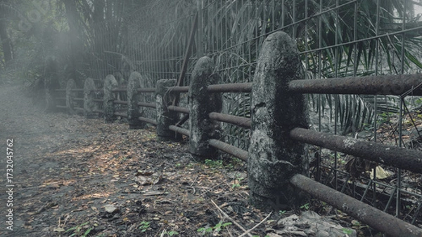 Fototapeta View of the old stone bridge path disappearing into the dense fog of a forest. The scene is scary and mysterious. Dramatic smoke or fog effect. Mockup. Copy Space. Wallpaper or Halloween background