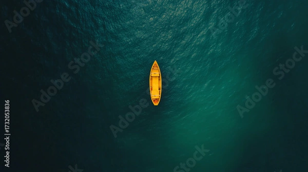 Fototapeta Aerial view of a bright yellow boat floating alone on a deep turquoise sea