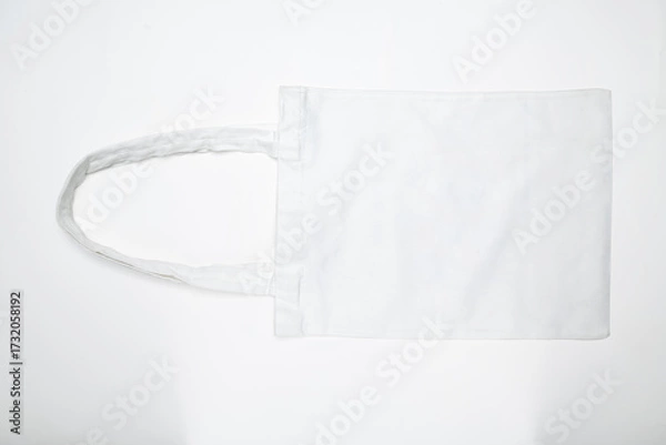 Fototapeta Top view of an eco-friendly white cotton canvas tote bag on a white background. Mockup, template, or copy space. Reusable bag for groceries and shopping