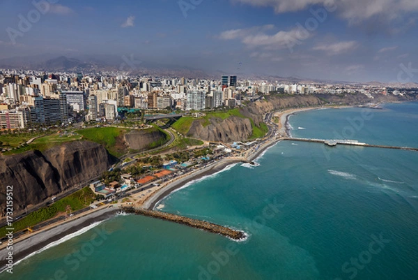 Fototapeta The thrill of paragliding over the stunning coastline of Miraflores is unmatched. With the ocean breeze at your back and the cityscape below.