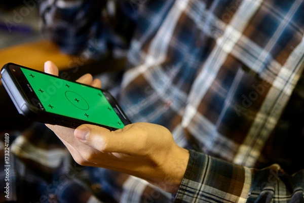 Fototapeta Horizontal closeup of man using smartphone indoors