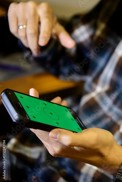 Fototapeta Man using smartphone with focus on screen indoors