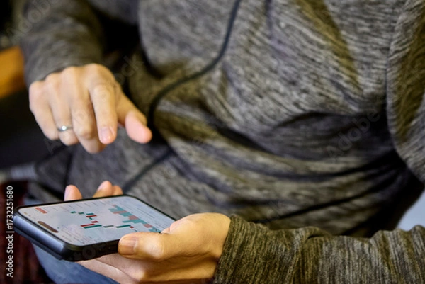 Fototapeta Grey hoodie man using smartphone with both hands