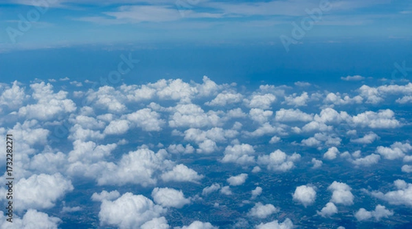 Fototapeta Beautiful landscape view trough window of airplane and cloudless sundown sky behind window of aircraft during flight. blue sky. Flying in the sky and the sea of clouds.