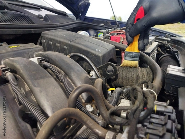 Obraz Car engine maintenance with brush cleaning in a garage