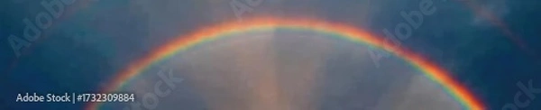 Fototapeta Vibrant rainbow arching across a dramatic, dark sky after a summer rain shower The colors are rich and saturated, offering a stunning natural spectacle , optical phenomenon, colorful sky