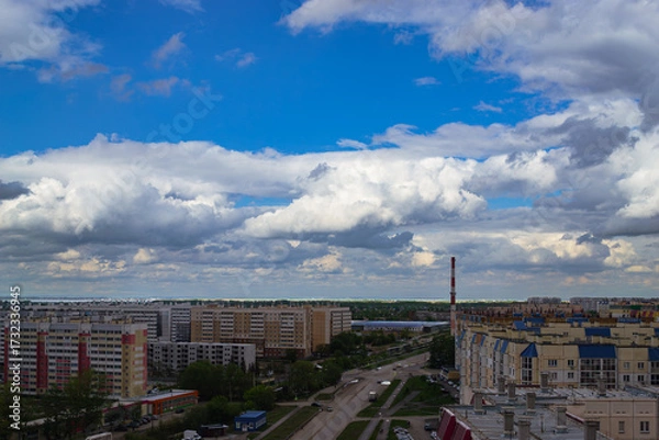 Fototapeta Panoramic cityscape with clouds and apartments