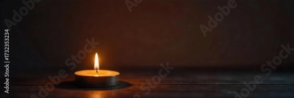 Fototapeta A single, flickering candle illuminates a dark room, casting warm, inviting shadows on the walls  Perfect for themes of relaxation, tranquility, and introspection ,  fire,  evening, candle