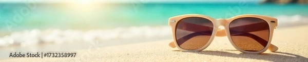 Fototapeta Stylish sunglasses resting on a sun-drenched beach, capturing the essence of summer relaxation and carefree vibes Perfect for travel, vacation, and summer fashion themes , sunny, ocean