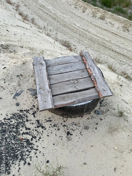 Fototapeta A well made of reinforced concrete rings covered with a wooden deck. Construction, drainage