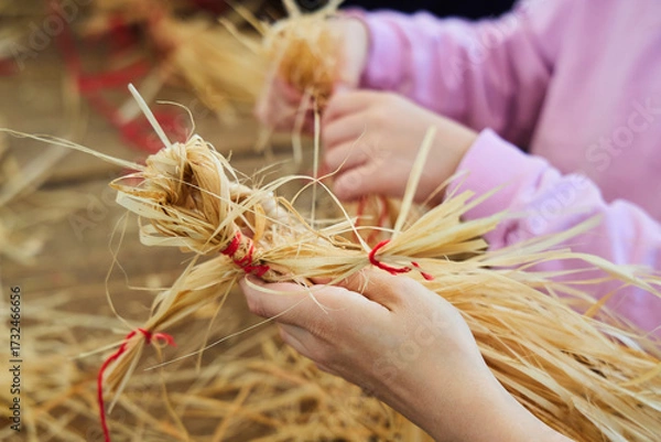 Fototapeta A master class on making straw dolls like in the 19th century. Close-up of the hands