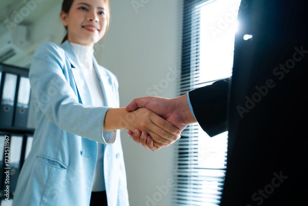 Fototapeta Business,job interview,career and placement concept.back view of two employers sitting and shaking hand of young asian woman,after successful negotiations or interview and Welcome to join in office
