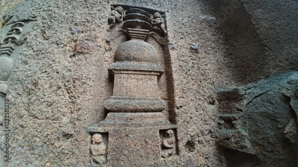 Obraz The Rich Texture and Fine Craftsmanship of Ancient Rock-Cut Reliefs Adorning a Wall in the Kanheri Cave Complex, Evoking Spiritual Heritage.