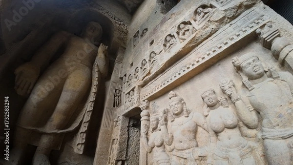 Obraz The Rich Texture and Fine Craftsmanship of Ancient Rock-Cut Reliefs Adorning a Wall in the Kanheri Cave Complex, Evoking Spiritual Heritage.