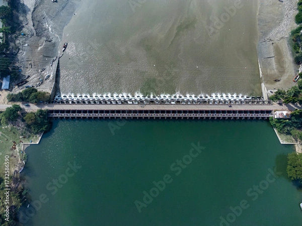 Fototapeta Aerial view of a water barrage with open gates and flowing water. 
The Muhuri Project, officially known as the Muhuri Irrigation Project (MIP), is a major water resource initiative in Bangladesh.