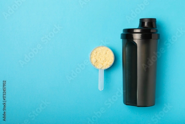 Fototapeta Protein shake with protein powder on a colored background. The powder is mixed with water or milk. A dietary supplement for a balanced diet. Whey protein. Fitness and gym diet nutrition.