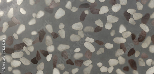 Fototapeta Closeup of a smooth gray surface with embedded white, gray, and brown pebbles, creating a textured and patterned background for various design applications