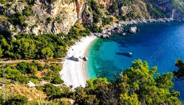 Obraz High-angle view of a pristine white beach nestled in a rocky cove, turquoise water, and lush greenery